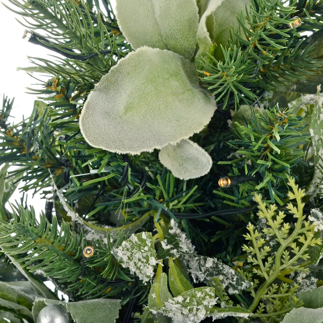 Detail of warm white LED lights, soft touch green leaves and mixed pine branches on a mini Christmas tree