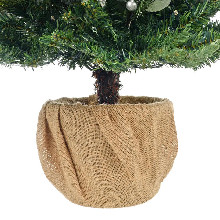 Jute covered base of a Christmas tree with LED lights, green pine and silver berries