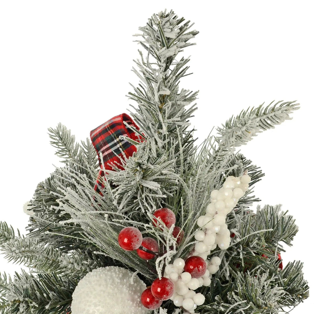 Close up of the top of a mini Christmas tree with red and white berries and frosted branches