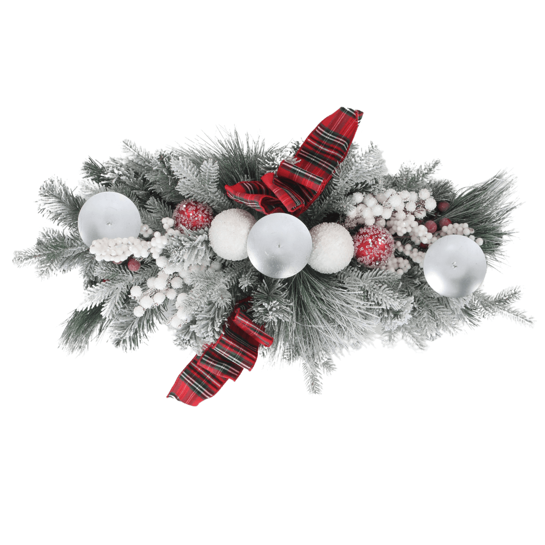 top view of table centrepiece featuring white and red snow covered baubles, snow berries and 3 candle holders