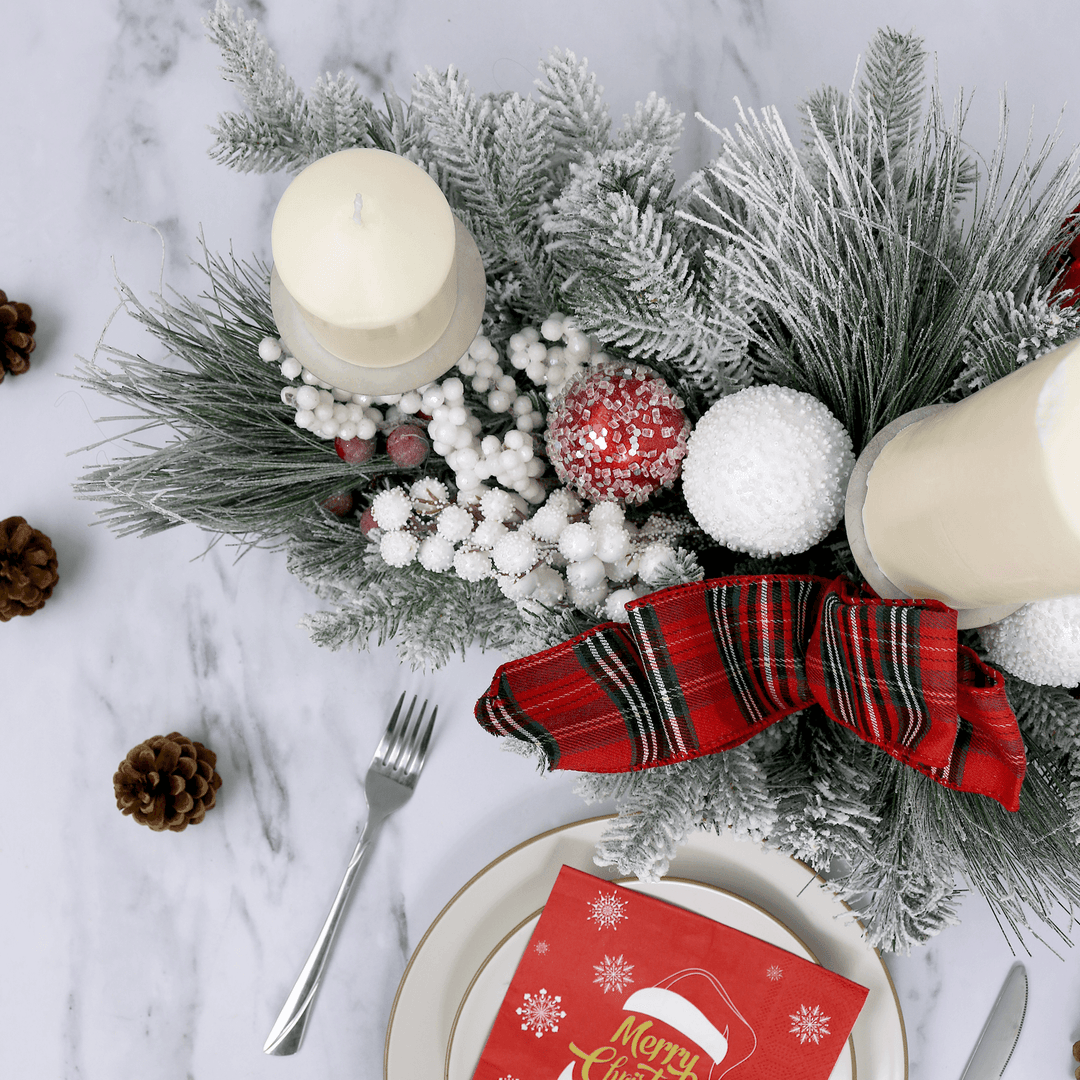 top view of centrepiece on marble table top beside plates with red napkin