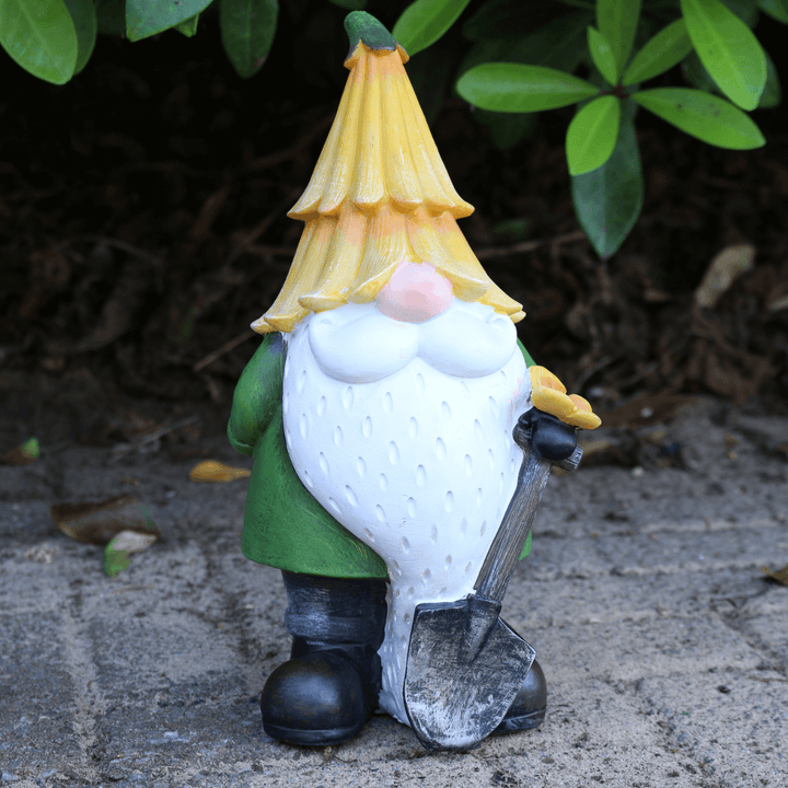 yellow hat gnome on outdoor patio space with foliage in background