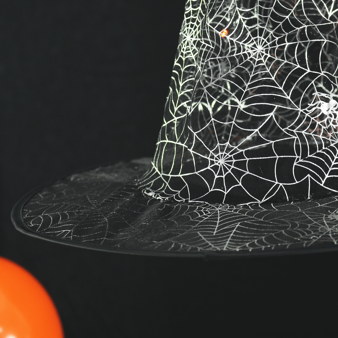 detail shot of silver web features on witches hat decoration with orange balloon to the side